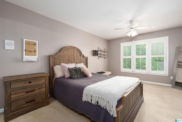 bedroom featuring baseboards, a ceiling fan, and light carpet