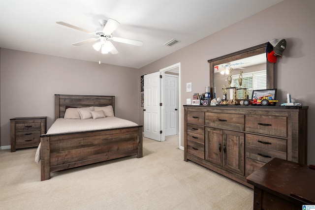 bedroom with a ceiling fan, visible vents, and light colored carpet