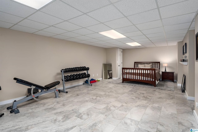 bedroom featuring a drop ceiling and baseboards