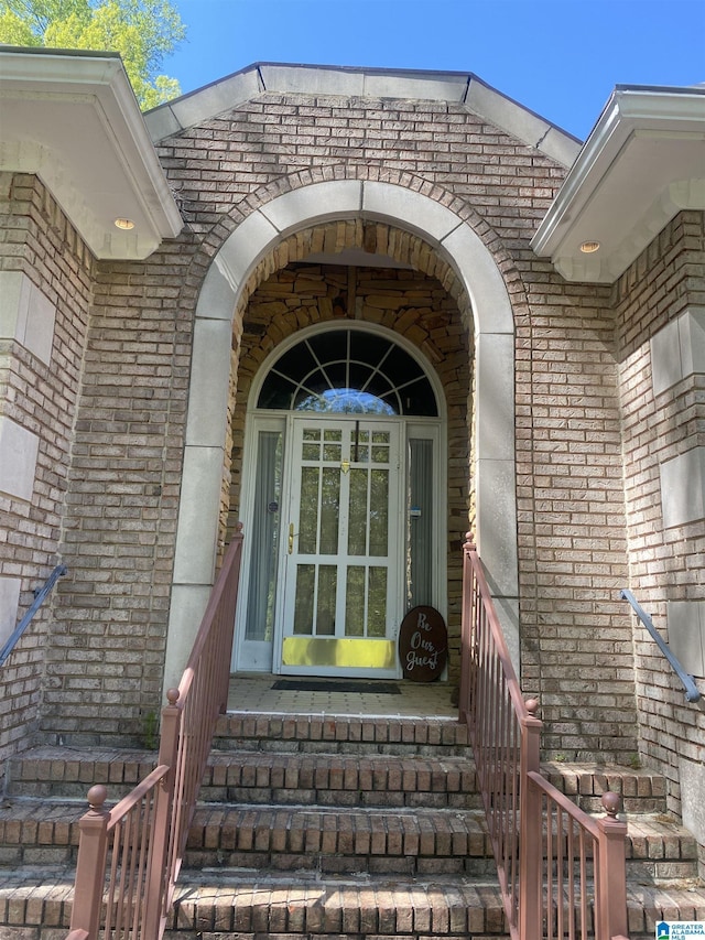 property entrance featuring brick siding