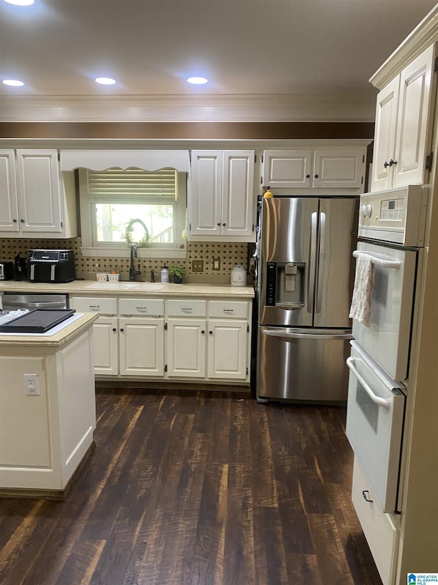 kitchen featuring crown molding, a sink, light countertops, and stainless steel fridge