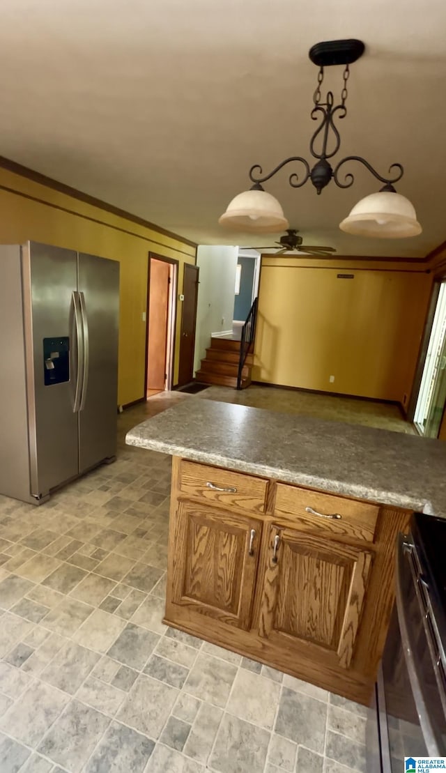 kitchen featuring stove, stone finish flooring, brown cabinetry, stainless steel refrigerator with ice dispenser, and ceiling fan