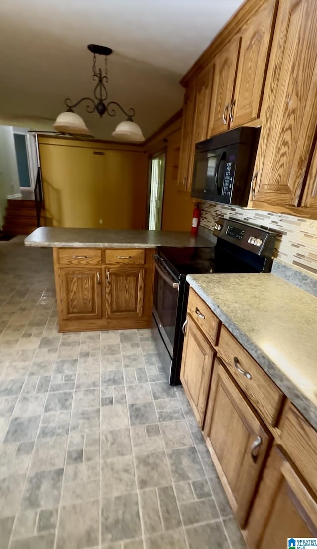 kitchen with a peninsula, black microwave, brown cabinets, and stainless steel electric range