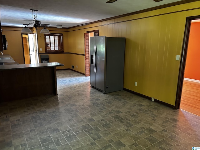 kitchen featuring stainless steel fridge, baseboards, and ornamental molding