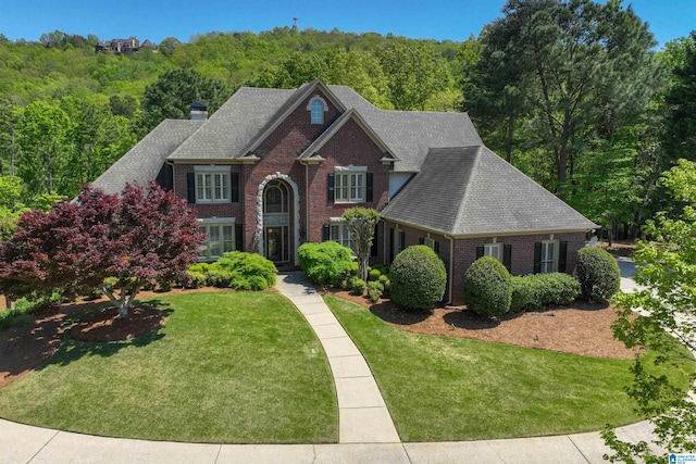 4527 High Court Cir, Hoover, AL 35242 - traditional home with a chimney, brick siding, a view of trees, a shingled roof, and a front yard