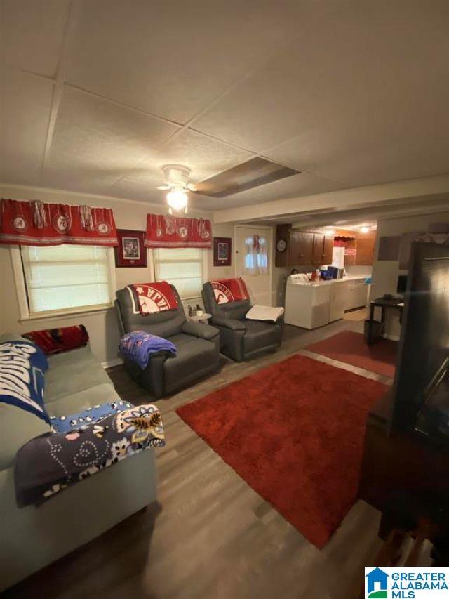living area with wood finished floors and ceiling fan