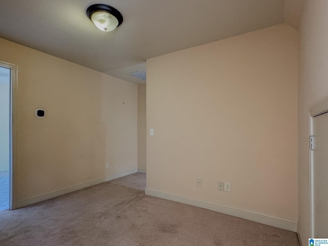 empty room featuring light carpet and baseboards