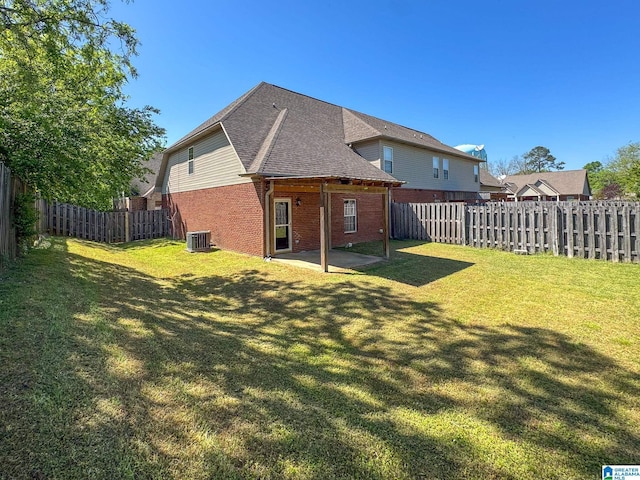 rear view of house featuring brick siding, a yard, a patio area, and a fenced backyard