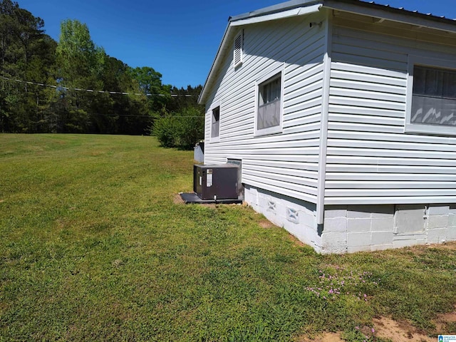 view of side of property with central AC, crawl space, and a yard
