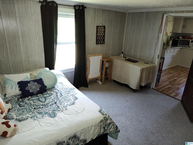 bedroom featuring wooden walls, a textured ceiling, and light colored carpet