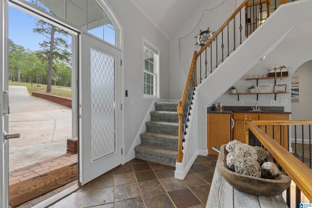 387 Misty Ln, Wedowee, AL 36278 - foyer entrance featuring stairs, stone tile flooring, baseboards, wet bar, and ornamental molding