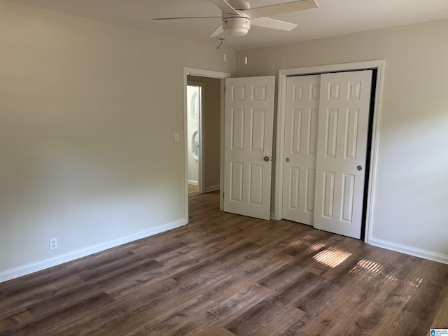unfurnished bedroom featuring baseboards, a closet, and dark wood-style floors