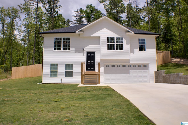 raised ranch with concrete driveway, a front lawn, a shingled roof, an attached garage, and fence