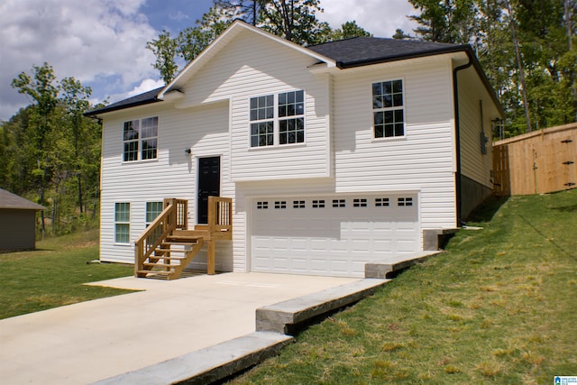 bi-level home featuring a garage, driveway, and a front yard