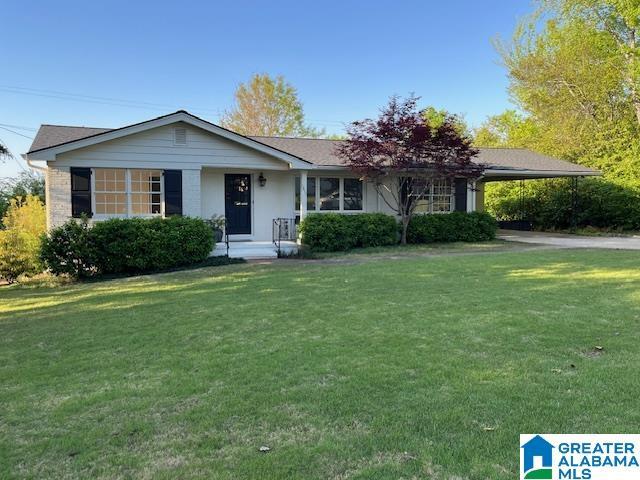 single story home featuring a front yard and an attached carport