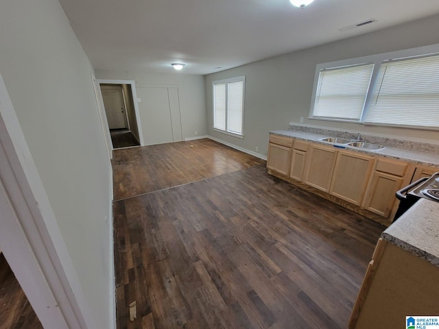 kitchen with a sink, dark wood finished floors, baseboards, electric range oven, and light brown cabinets