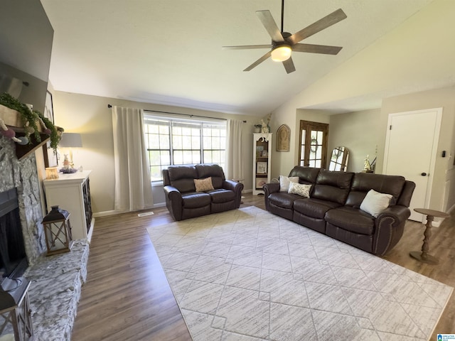632 Bernard Couch Dr, Anniston, AL 36207 - living area featuring high vaulted ceiling, a ceiling fan, a stone fireplace, baseboards, and wood finished floors
