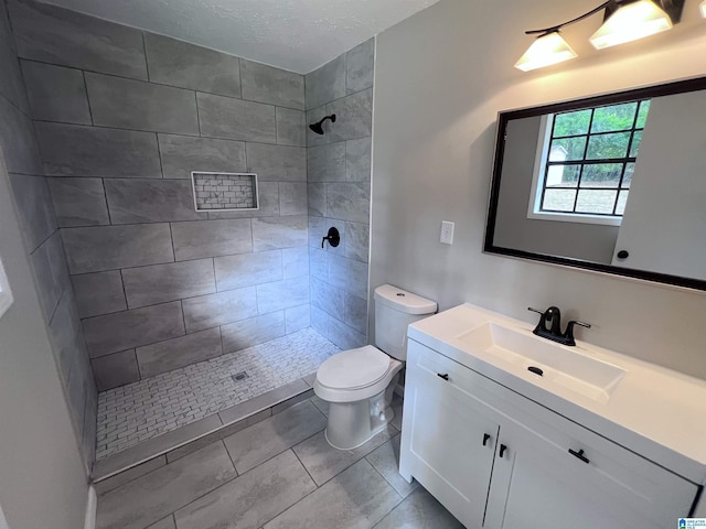 632 Bernard Couch Dr, Anniston, AL 36207 - full bath featuring tiled shower, tile patterned flooring, toilet, vanity, and a textured ceiling