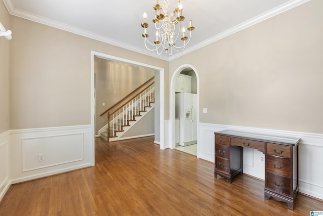 43 Dogwood Dr, Calera, AL 35040 - unfurnished dining area with arched walkways, a wainscoted wall, a chandelier, ornamental molding, and stairs