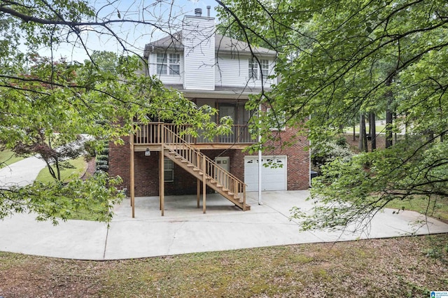 43 Dogwood Dr, Calera, AL 35040 - back of property with a chimney, stairs, brick siding, concrete driveway, and an attached garage