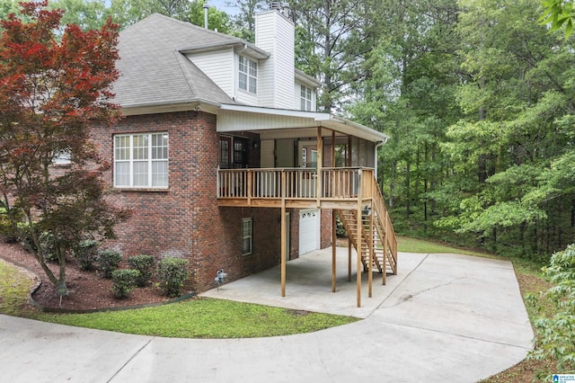 43 Dogwood Dr, Calera, AL 35040 - back of house featuring a garage, a chimney, brick siding, stairs, and driveway