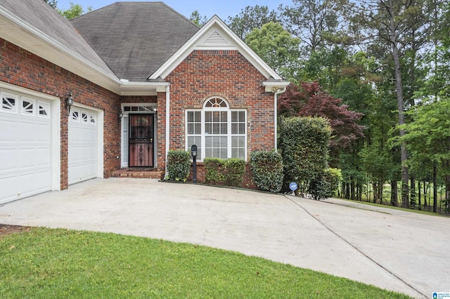 43 Dogwood Dr, Calera, AL 35040 - property entrance featuring brick siding, driveway, roof with shingles, and a garage