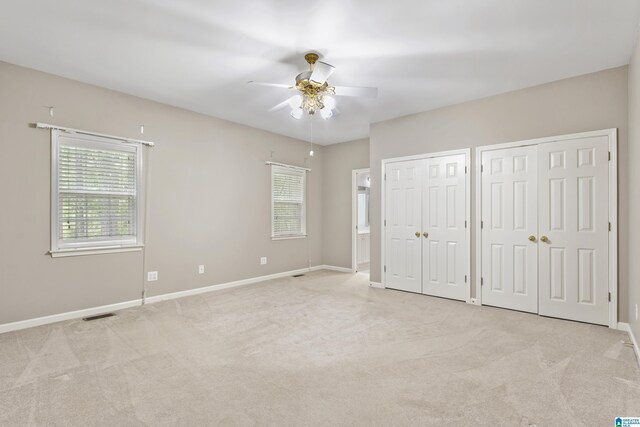 43 Dogwood Dr, Calera, AL 35040 - unfurnished bedroom featuring light colored carpet, baseboards, multiple closets, and multiple windows