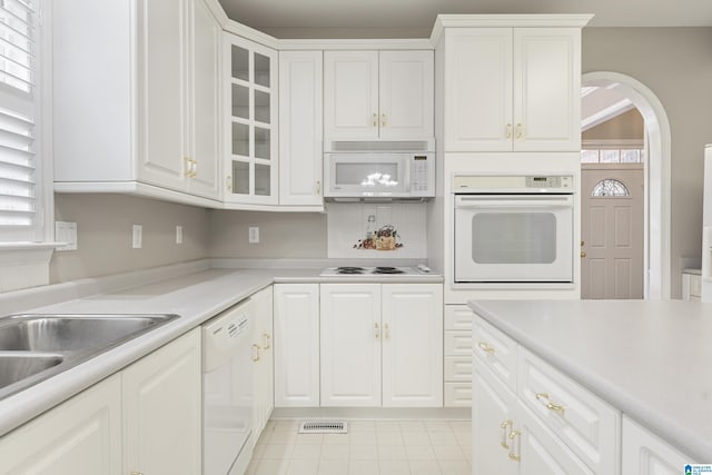 43 Dogwood Dr, Calera, AL 35040 - kitchen featuring arched walkways, light countertops, glass insert cabinets, white appliances, and white cabinetry