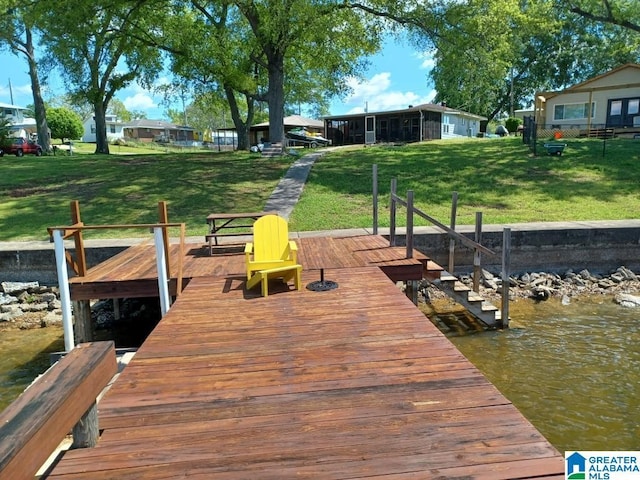 view of dock featuring a yard and a water view