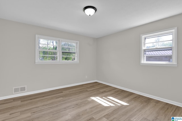 spare room with baseboards, a healthy amount of sunlight, and visible vents