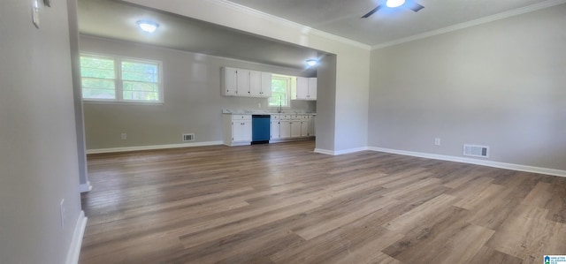 unfurnished living room featuring ceiling fan, ornamental molding, wood finished floors, and visible vents
