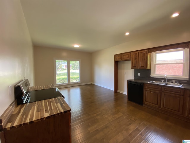 kitchen with a sink, baseboards, black dishwasher, dark wood-style floors, and recessed lighting