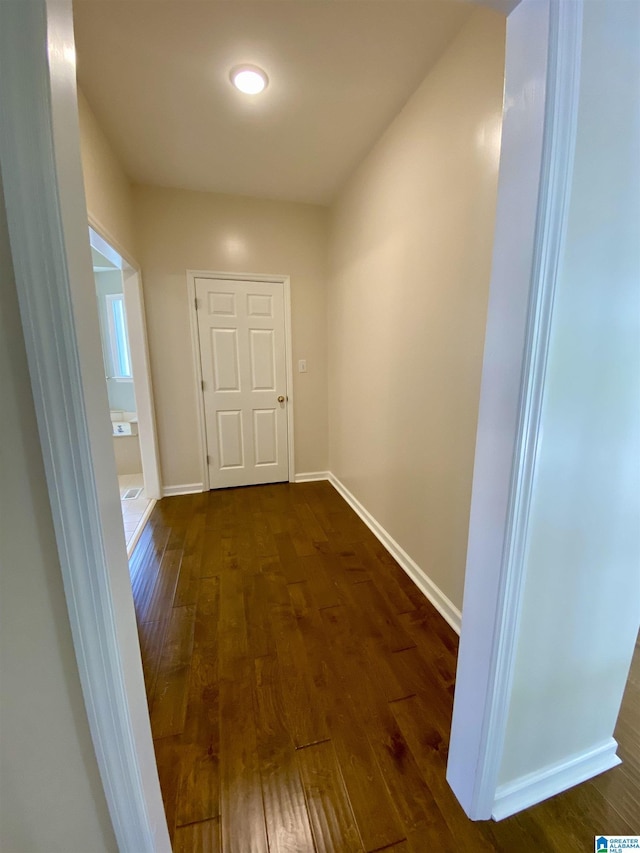 hall with baseboards and dark wood-style floors