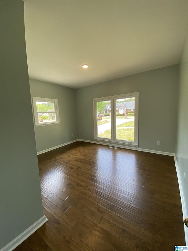 spare room featuring recessed lighting, visible vents, baseboards, and dark wood-style flooring