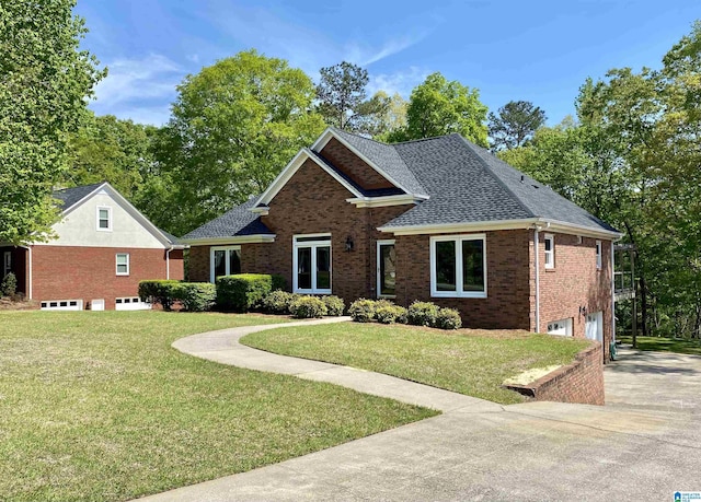 view of front of home with a shingled roof, concrete driveway, an attached garage, brick siding, and a front yard