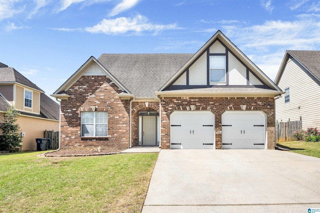 view of front of home with fence, brick siding, a front yard, and concrete driveway