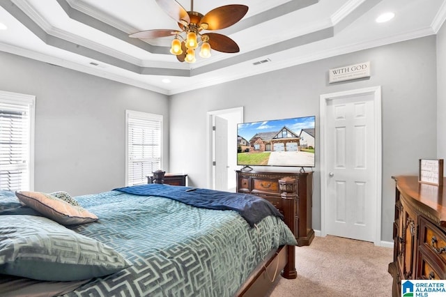 bedroom featuring light carpet, crown molding, a tray ceiling, and visible vents