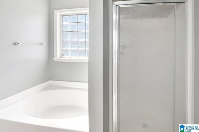 bathroom featuring a garden tub and a stall shower
