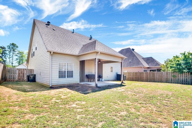 rear view of property with a patio area, a ceiling fan, a fenced backyard, a yard, and roof with shingles