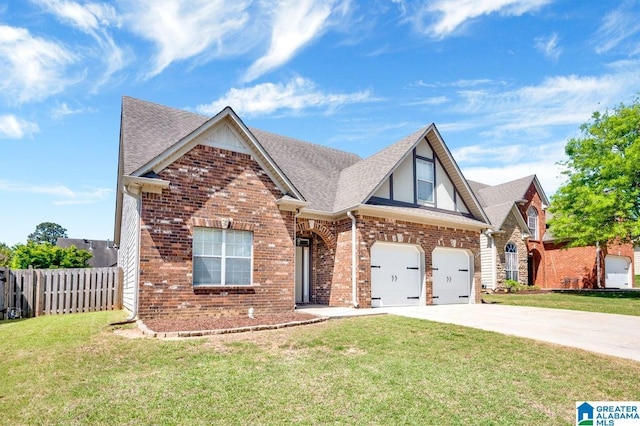 view of front of house with brick siding, driveway, fence, and a front yard