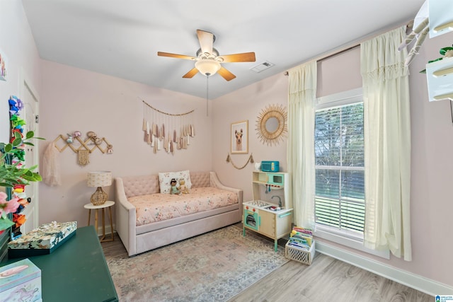 bedroom featuring wood finished floors, visible vents, baseboards, and ceiling fan