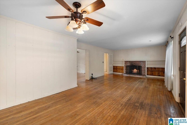 1203 Park Ave, Oneonta, AL 35121 - unfurnished living room with a fireplace, wood-type flooring, and a ceiling fan
