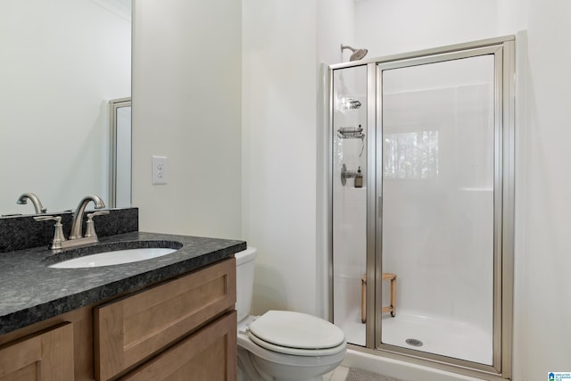 full bathroom with toilet, vanity, and a stall shower