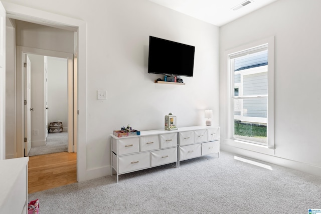 bedroom featuring baseboards, visible vents, and light colored carpet