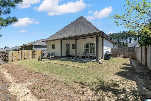 rear view of property featuring a fenced backyard, a patio, a shingled roof, and a lawn