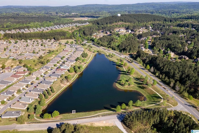 drone / aerial view with a residential view, a wooded view, and a water view