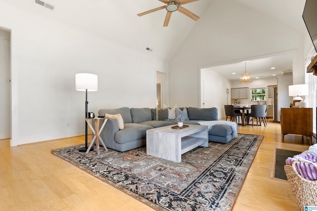 living area featuring light wood-style flooring, visible vents, high vaulted ceiling, and ceiling fan