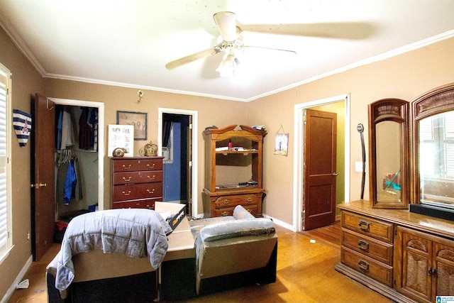 bedroom with a closet, crown molding, baseboards, light wood-style flooring, and ceiling fan