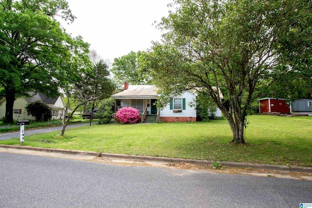 view of front facade featuring crawl space, an outbuilding, and a front yard