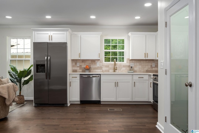 kitchen with ornamental molding, light countertops, appliances with stainless steel finishes, and white cabinetry